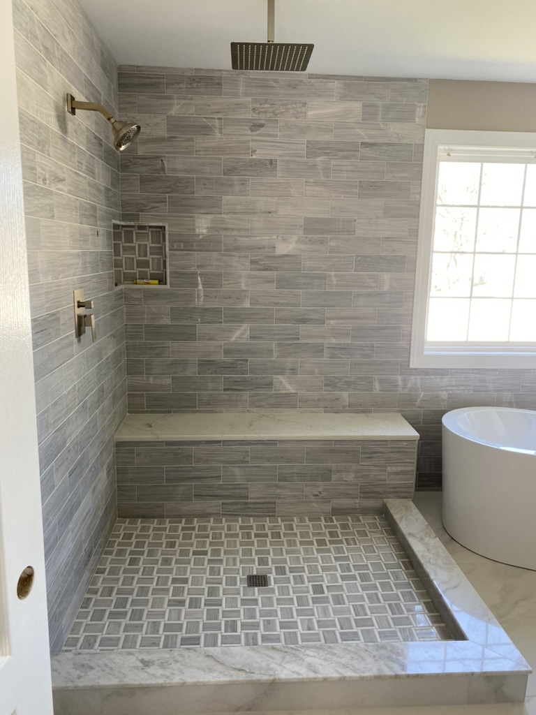Tile tub surround with niche and matte black fixtures.