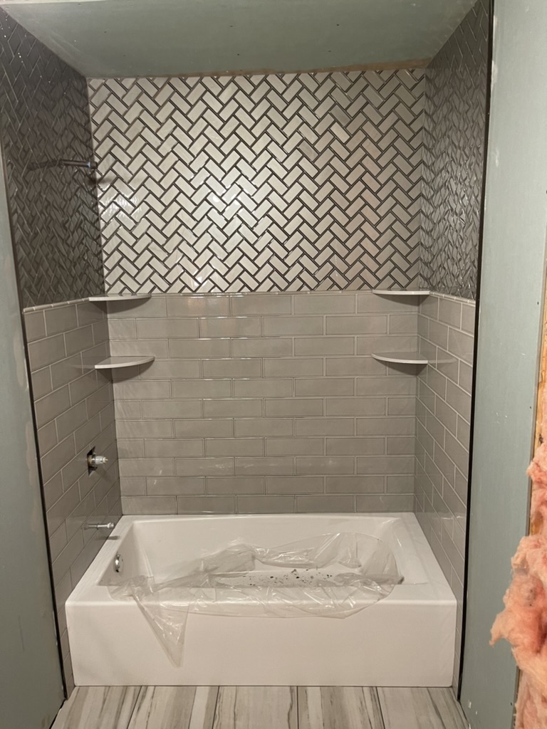Finished bathroom remodel with new tile shower, niche, and updated fixtures.